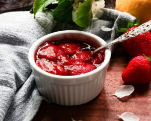 strawberry compote in small white pot with spoon