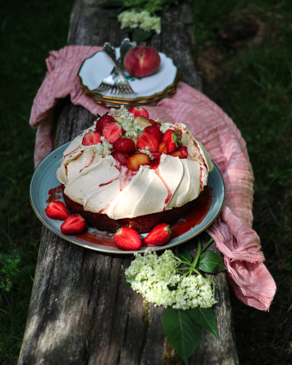Saffron rice cake with pavlova crown on a green plate on a wooden bank