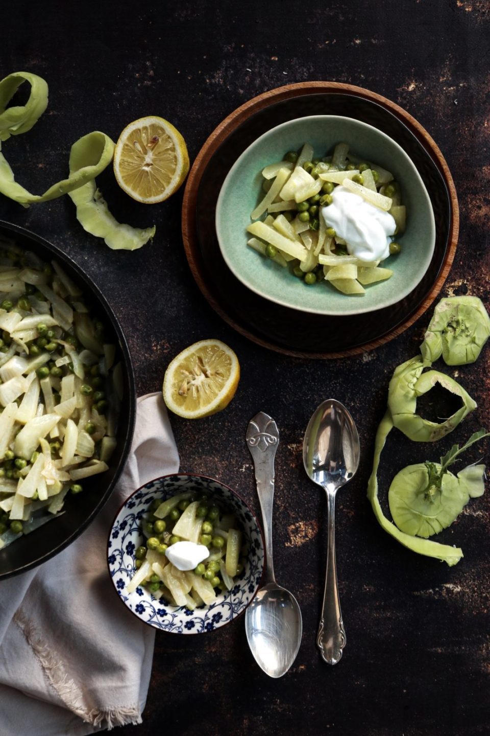 kohlrabi and peas with coconut milk and ginger in a green bowl with ingredients around