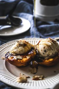grilled peaches, honey drizzle, ice cream on white plate