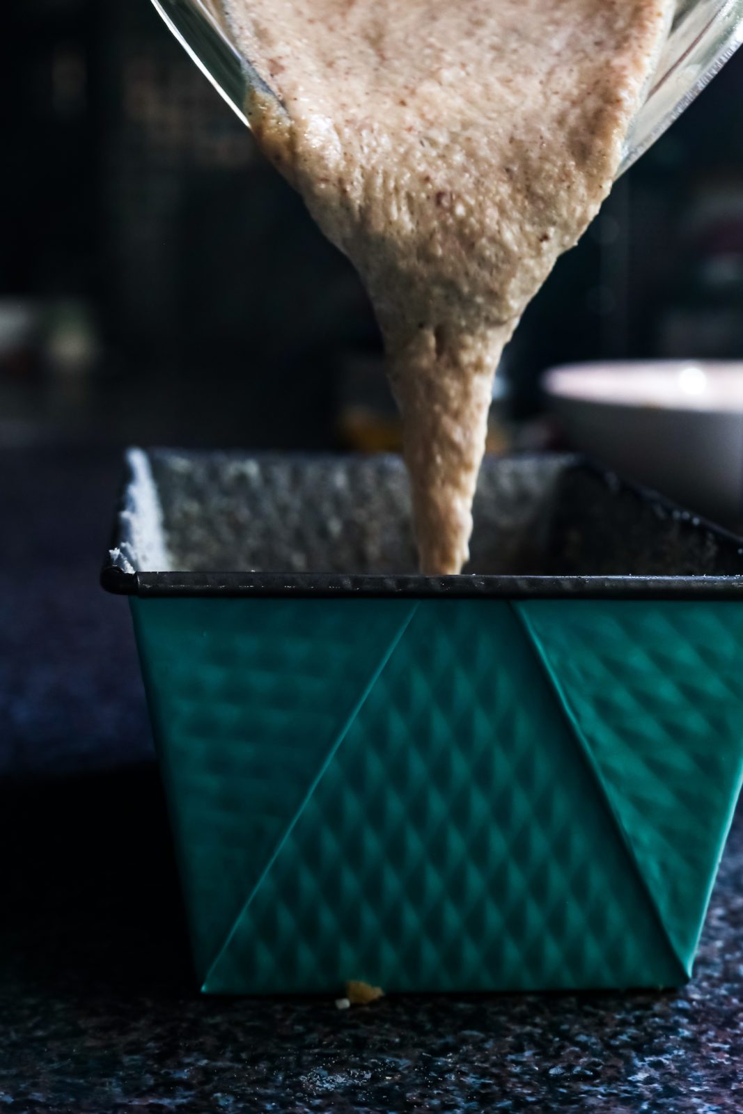 pouring dough into a cake pan