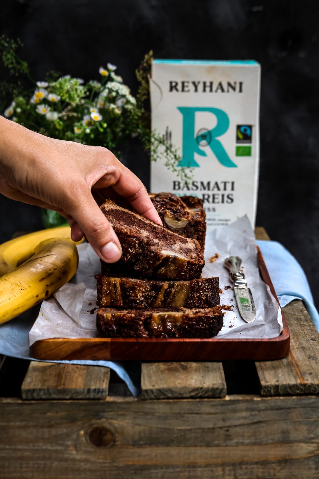 hand taking a slice of banana bread