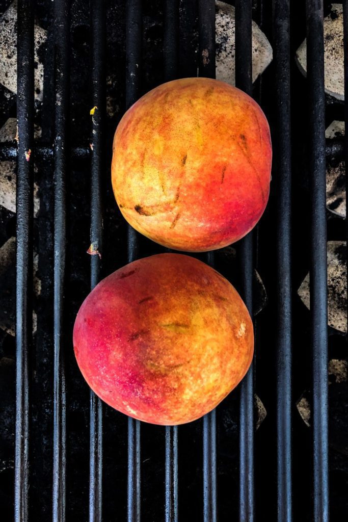 two peaches halves on the grill