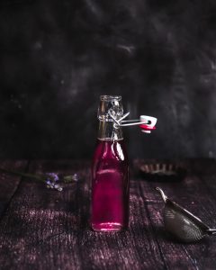 Bottle with homemade lavender syrup on a dark wooden surface