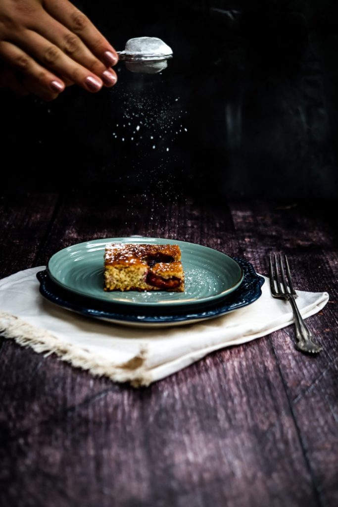 piece of plum sheet cake on a light green plate.