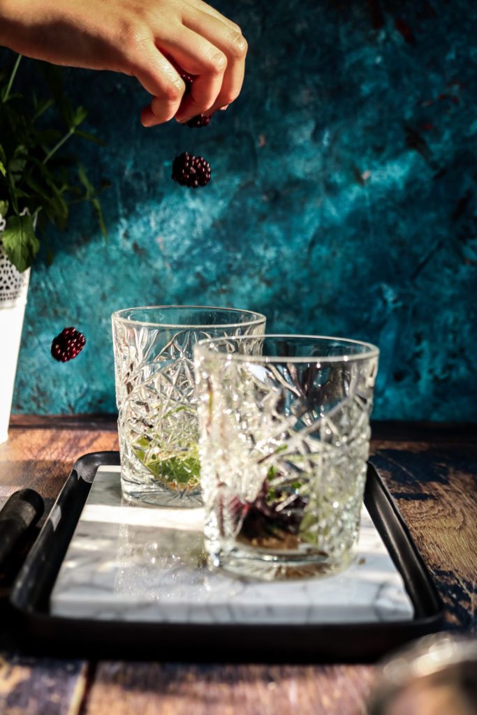 Falling blackberries into glasses