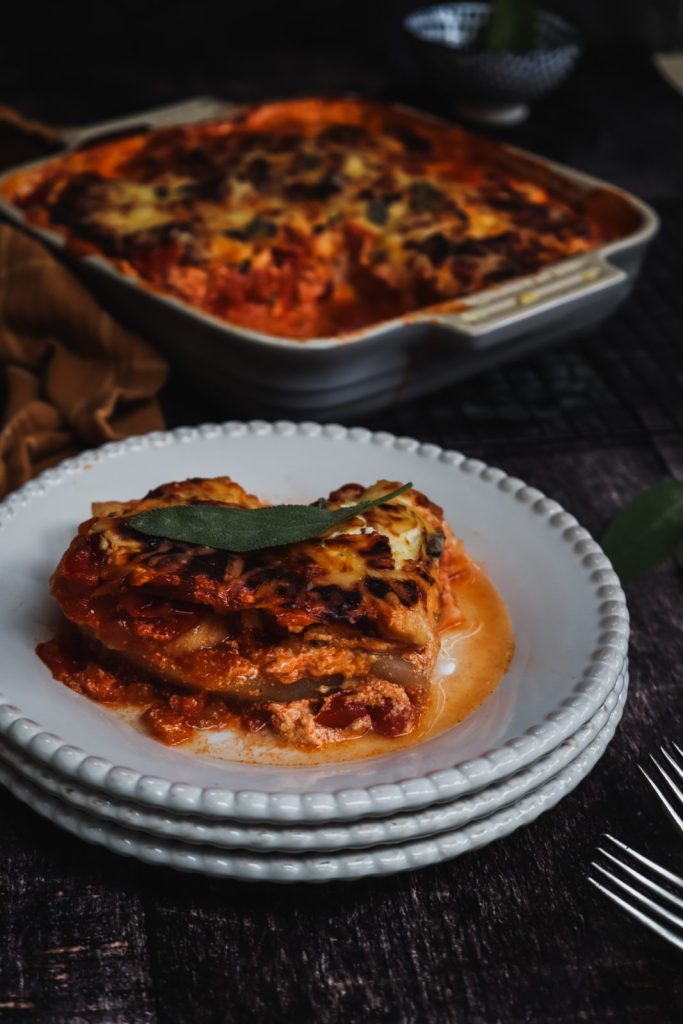 one piece of kohlrabi lasagna on 3 white plates