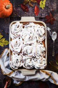 cinnamon brioche rolls in a baking sheet with autumnally decoration